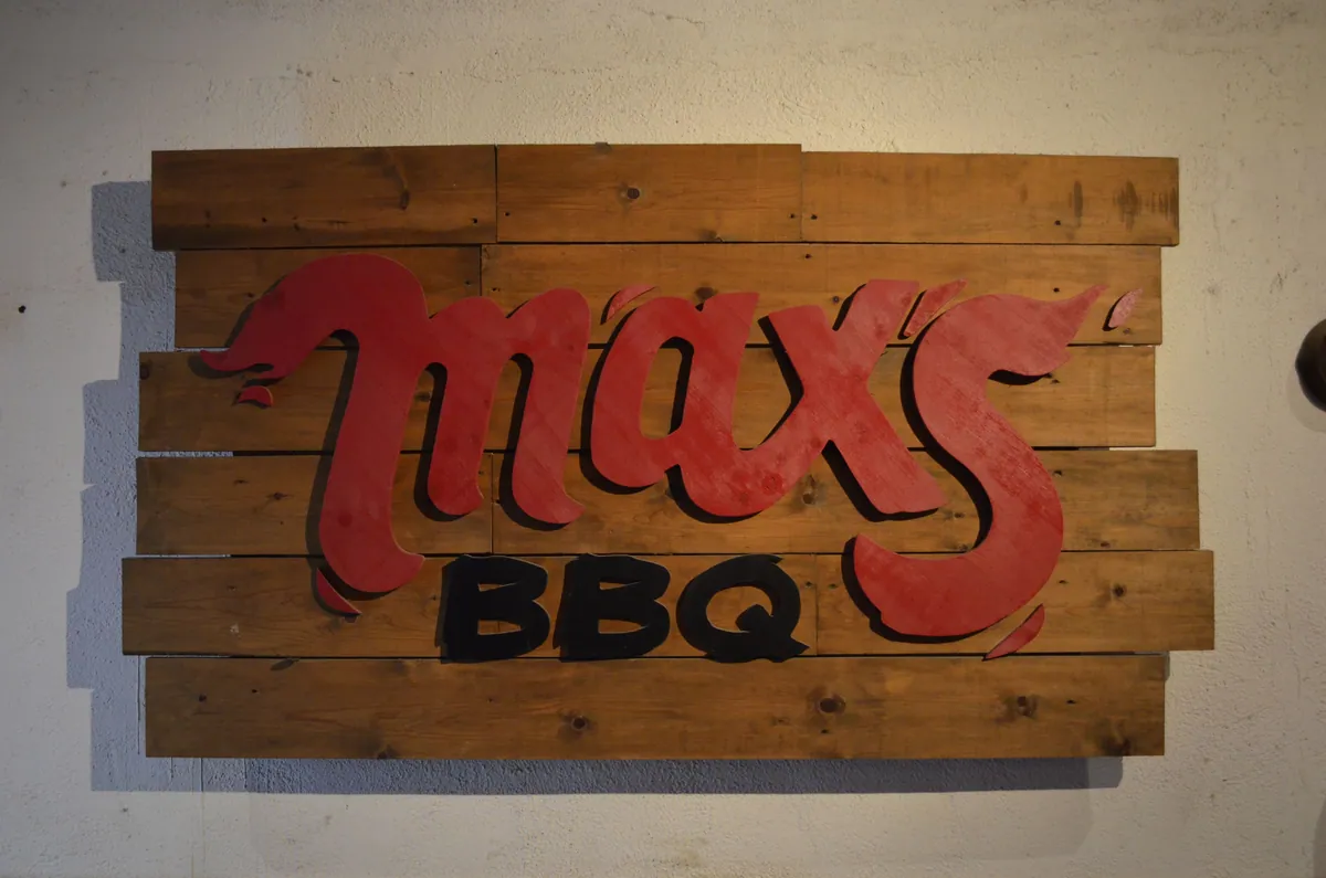 Letrero de madera de Max's BBQ tallado en la pared del restaurante