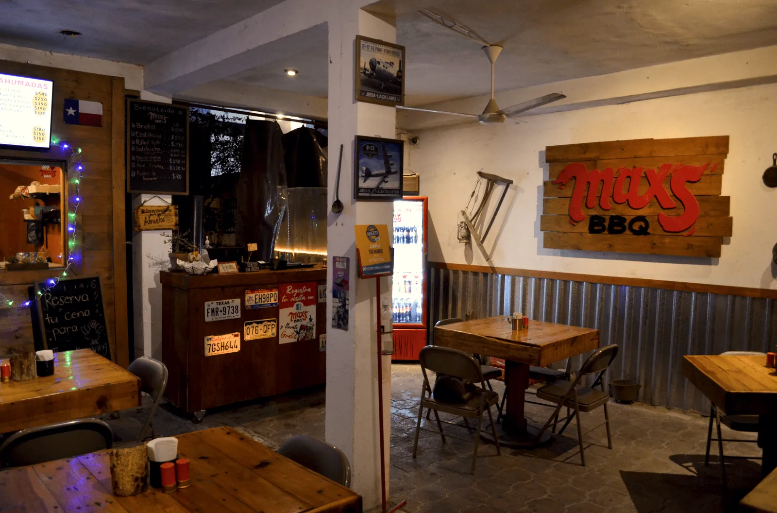 Comedor de Max's BBQ con paredes de madera, lámina y el logo tallado